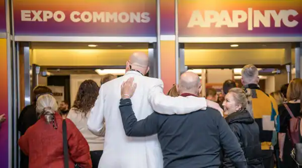 Two APAP Members arm in arm going in the EXPO Hall at APAPNYC 2025 (Photo by Adam KissickAPAP)